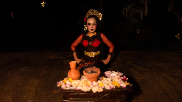 a female dancer sits gracefully and begins her ritual in front of beautiful offerings photo