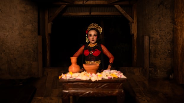 a female dancer sits gracefully and begins her ritual in front of beautiful offerings photo