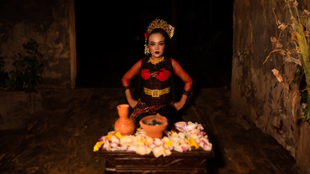 a female dancer sits gracefully and begins her ritual in front of beautiful offerings photo