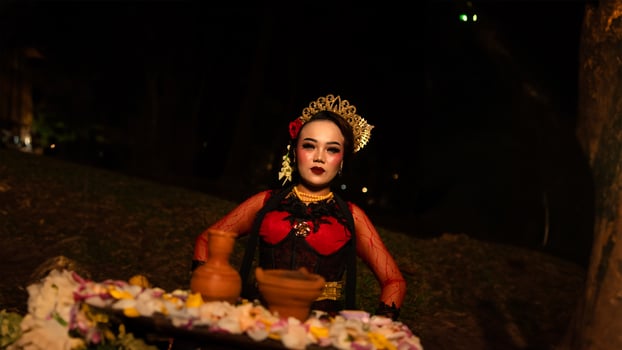 a female dancer who looks beautiful in a red costume performs a ritual that radiates an aura of beauty and purity photo