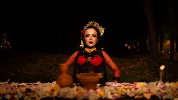 a female dancer who looks beautiful in a red costume performs a ritual that radiates an aura of beauty and purity photo