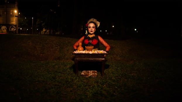 a female dancer who looks beautiful in a red costume performs a ritual that radiates an aura of beauty and purity photo