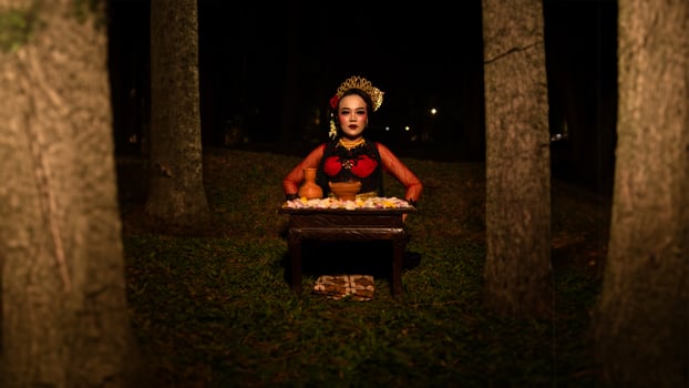 a female dancer who looks beautiful in a red costume performs a ritual that radiates an aura of beauty and purity photo