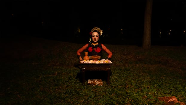 a female dancer who looks beautiful in a red costume performs a ritual that radiates an aura of beauty and purity photo