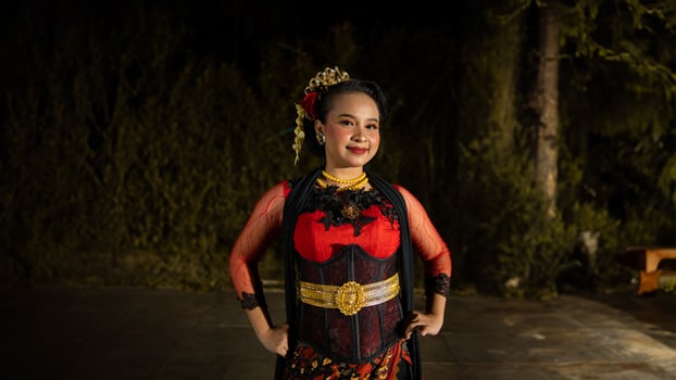 an Indonesian dancer radiates charm that attracts the attention of the audience throughout the performance with her red dress photo