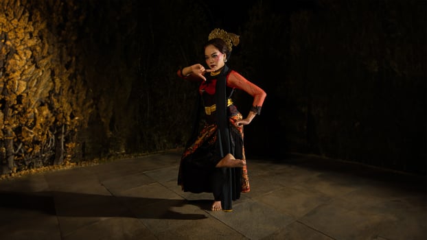 A Sundanese dancer wears a beautiful sparkling red costume and dances with a passionate expression photo