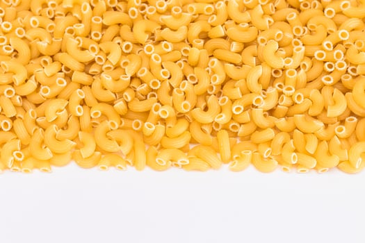 Uncooked Chifferi Rigati Pasta Scattered on White Table. Fat and Unhealthy Food. Classic Dry Macaroni. Italian Culture and Cuisine. Raw Pasta photo
