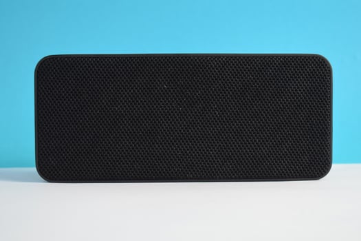 Wireless black Speaker box for play music on blue background, Wireless Music player, electronic. photo