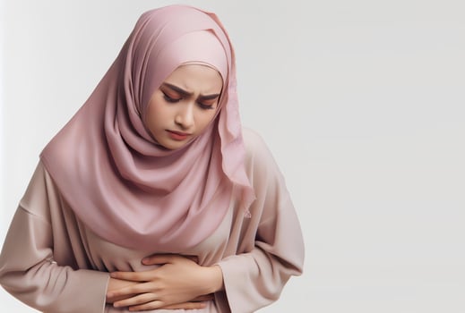 AI generated asian muslim woman in hijab with hands holding stomach with pain facial expression isolated white background photo