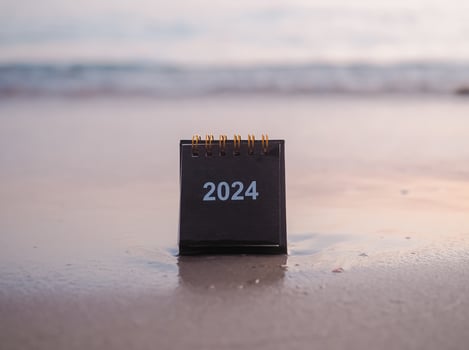 Close up 2024 desk calendar on the beach in the sunset time. Resolution, Goal, Action, Planning, and manage to success business. photo