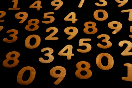 Colorful wooden numbers on a blackboard background with space for text photo
