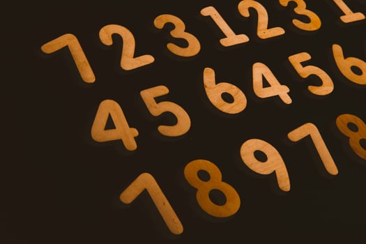 Colorful wooden numbers on a blackboard background with space for text photo