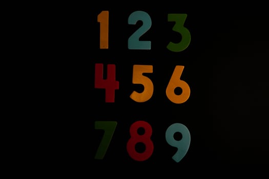 Colorful wooden numbers on black background. Number 1 to 9. photo