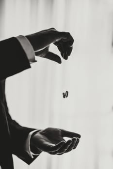 The man has two wedding rings on his hand. The groom throws wedding rings. Groom holds rings. Wedding traditions. Golden rings lie on the palm of a person. Black and white photo. photo