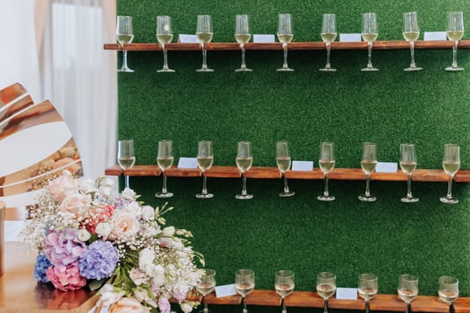 Stand for glasses. A luxurious wedding ceremony. Romantic wedding ceremony. Champagne glasses on a green background. Wedding details photo