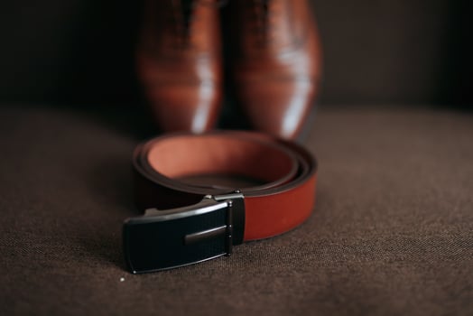 Men's shoes and belt. Elegant red men's leather shoes and belt on a brown background. Men's style. Fashion. Business photo