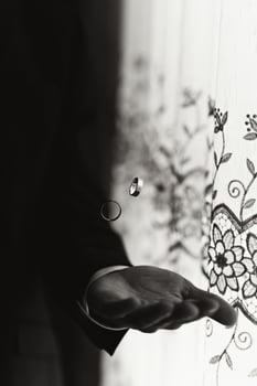 Photo of wedding accessories. Golden rings are tossed in the air. A moment before falling. Style and fashion