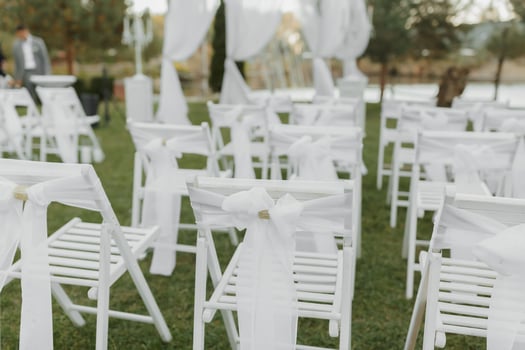 wedding ceremony by the lake. A luxurious wedding ceremony. Romantic wedding ceremony. The presidium is decorated with white flowers. White chairs photo