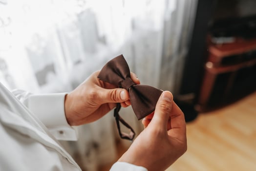 man butterfly clothes,businessman putting on bow tie. Suit, Hands, care, tie, to correct, to adjust, fashion, bow. photo