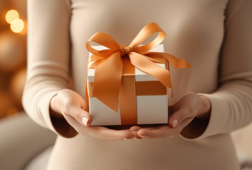 AI generated a womans hand holds the gift box with a ribbon photo