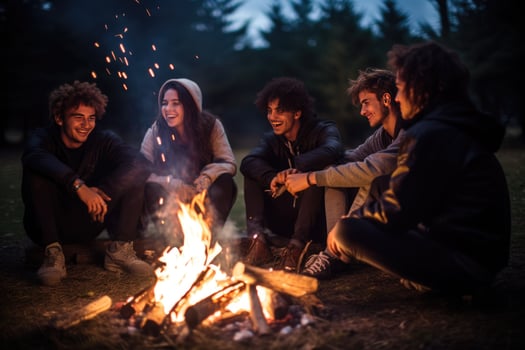 AI generated Group of young friends sitting near bonfire at night Camping concept, Young people sitting around a bonfire Ai generated photo