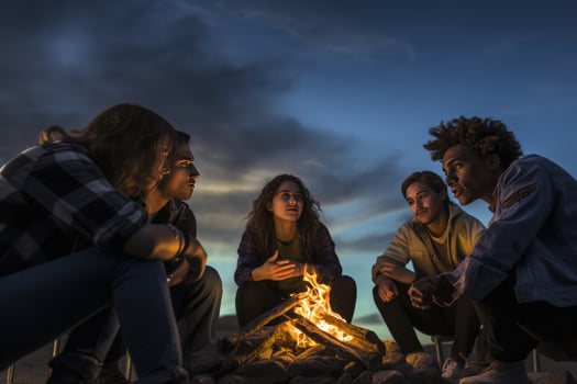 AI generated Group of young friends sitting near bonfire at night Camping concept, Young people sitting around a bonfire Ai generated photo