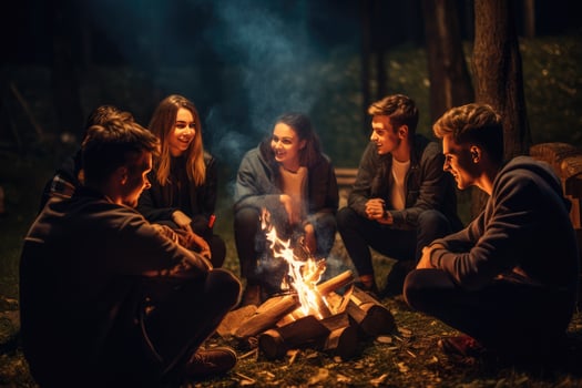 AI generated Group of young friends sitting near bonfire at night Camping concept, Young people sitting around a bonfire Ai generated photo