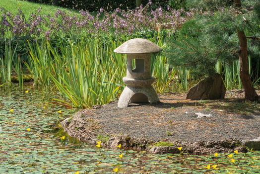 stone lantern on a small island in the middle of a pond in a Japanese garden photo