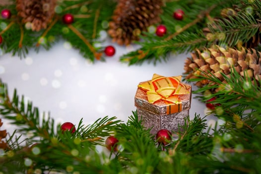 Christmas holiday picture in red and green colors, gift box, cones, green spruce branches, red balls, berries. Background for New Year and Christmas. photo