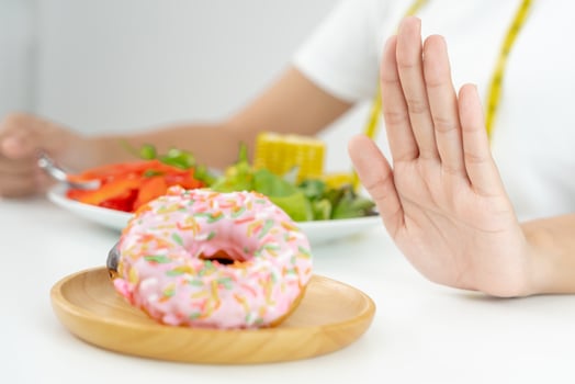 Diet and dieting. Beauty slim female body confuse donut. Woman in exercise clothes achieves weight loss goal for healthy life, crazy about thinness, thin waist, nutritionist. photo