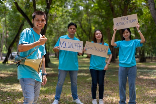Happy young Asian students diverse volunteers hold a campaign sign for cleaning in the park, The concept of environmental conservation on world environment day, recycling, charity for sustainability. photo