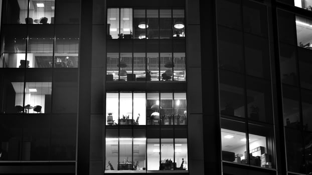 Pattern of office buildings windows illuminated at night. Glass architecture ,corporate building at night - business concept. Black and white. photo