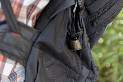 A person who wear a backpack with bear bell at the green forest in Autumn photo
