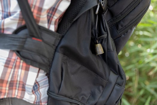 A person who wear a backpack with bear bell at the green forest in Autumn photo
