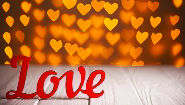 the inscription Love on a wooden background with beautiful hearts made of lights on a blurred background photo