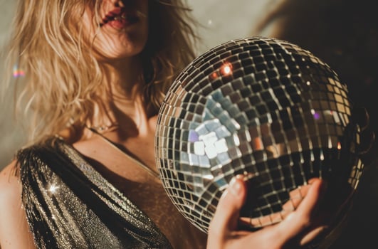 AI generated woman with disco ball next to backdrop, silver and amber photo