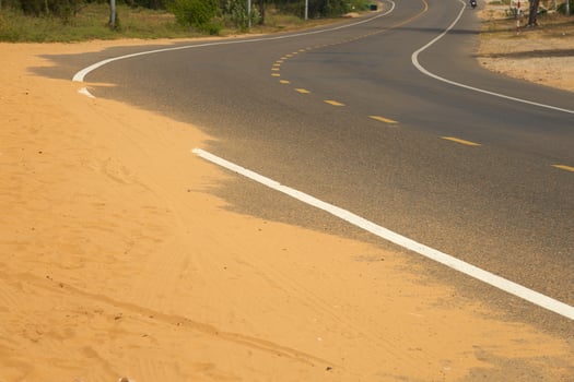 Desert sand steps on an asphalt road. photo