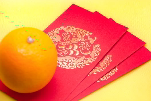 Chinese New Year red packets and orange on yellow cover background. Chinese festive season concept and copy space. photo