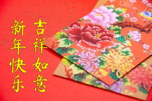 Close up of colorful envelope on red cover background with Chinese New Year wishes photo