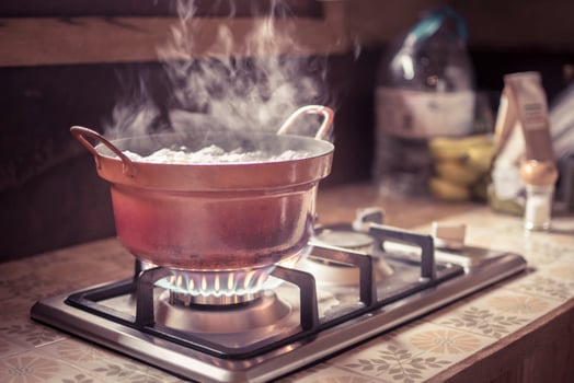 Worn out stove pot or cooking pan on a burning gas hob photo