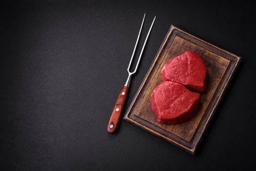 Fresh juicy raw filet mignon with salt, spices and herbs photo