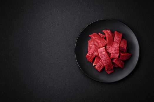 Juicy fresh raw beef meat with salt, spices and herbs photo