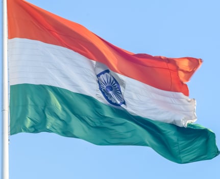 India flag flying high at Connaught Place with pride in blue sky, India flag fluttering, Indian Flag on Independence Day and Republic Day of India, tilt up shot, Waving Indian flag, Har Ghar Tiranga photo