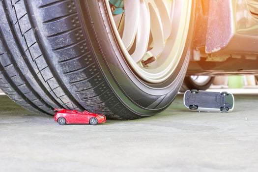 Toy car accident concept with wheel of car toy on cement floor photo
