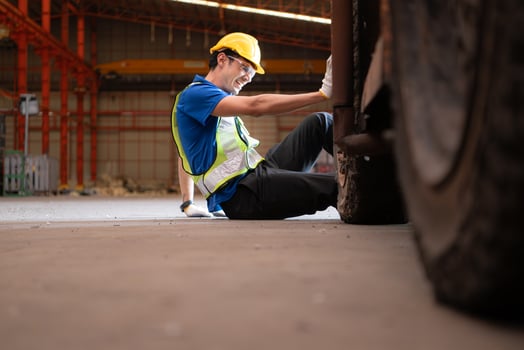 Young man working in a steel industry factory. He was critically hurt when a forklift ran over his leg and had to be transported to the hospital. photo