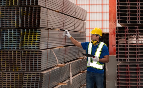 Warehouse worker in hard hats and helmets stand in the warehouse to count and inspect the steel in the warehouse. photo
