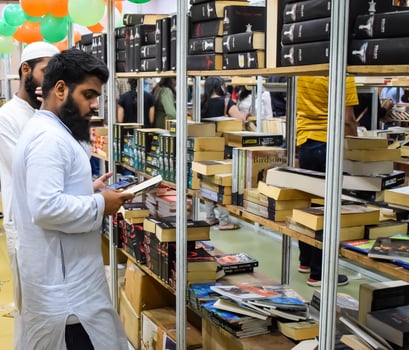 Delhi, India, September 09 2023 - Various age group people reading variety of Books on shelf inside a book-stall at Delhi International Book Fair, Selection of books on display in Annual Book Fair photo