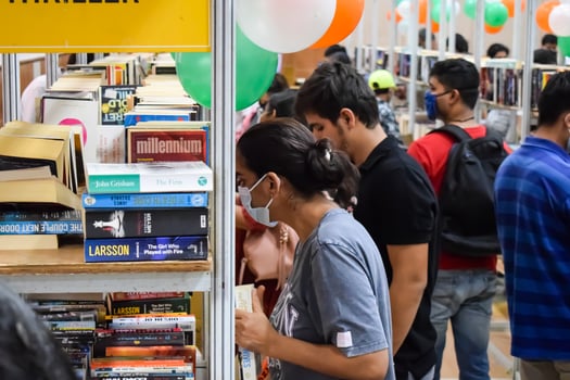Delhi, India, September 09 2023 - Various age group people reading variety of Books on shelf inside a book-stall at Delhi International Book Fair, Selection of books on display in Annual Book Fair photo