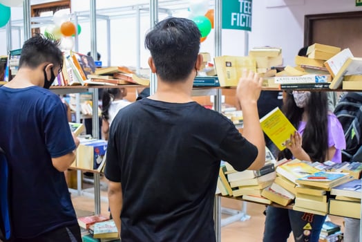 Delhi, India, September 09 2023 - Various age group people reading variety of Books on shelf inside a book-stall at Delhi International Book Fair, Selection of books on display in Annual Book Fair photo