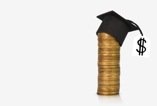 Concept of financial literacy and education. Graduation hat on a column of gold coins. Copy space photo